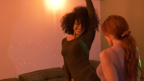excited female friends grooving to music during weekend party at home