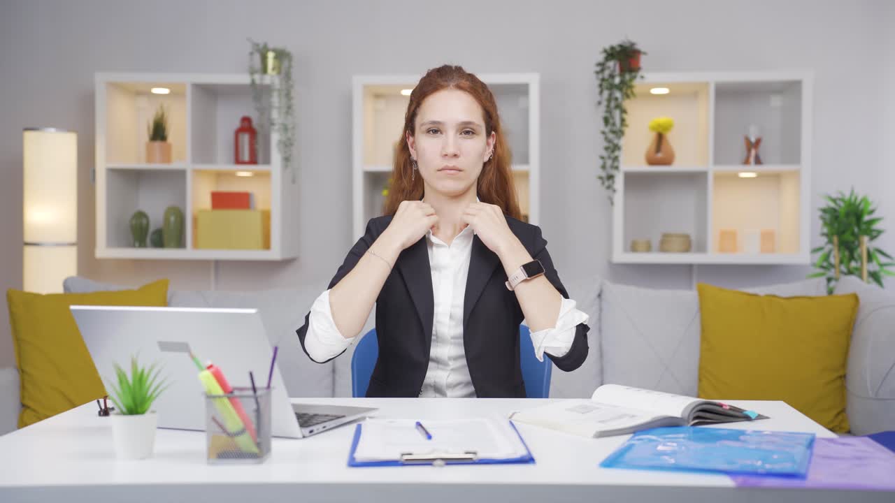 Home office worker woman looks at camera with happy and smiling face.
