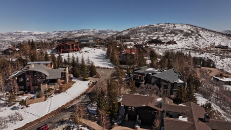 park city utah aerial v14 snowy winter mountainscape view, drone low level fly around hilltop luxurious mansions capturing expensive home under construction - shot with mavic 3 cine - february 2022