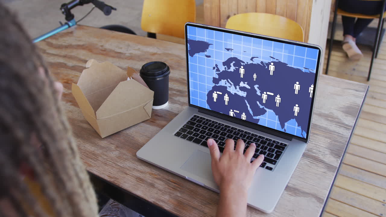 hombre de negocios biracial usando una computadora portátil con red de comunicación en la pantalla en la oficina.