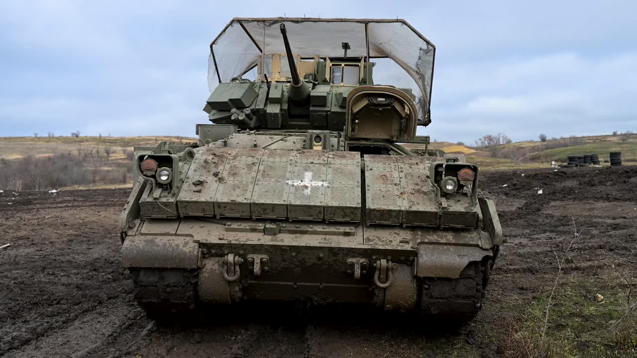This M2 Bradley IFV serves a dual role in Ukraine's army. The medical cross marks it for casualty evacuation (CASEVAC), while cage armor is vital for surviving drone warfare