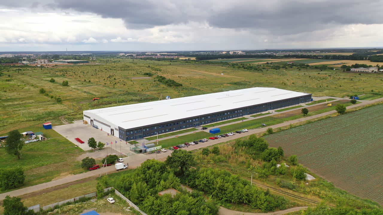 Modern industrial complex in the rural place. View from the air on commercial building in summer time. Aerial view.