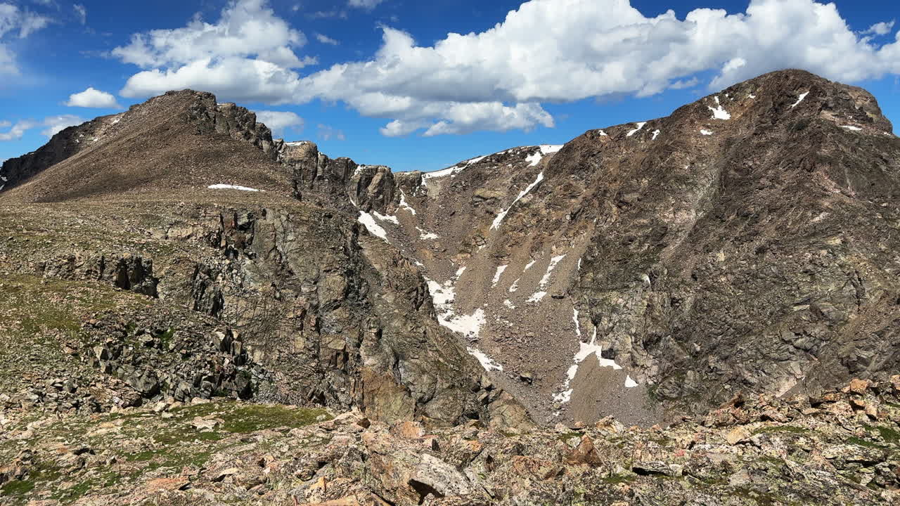 Halo Ridge trail Notch Mountain Mount Holy Cross Wilderness catwalk Ridge saddle summit Peak 14er Colorado Sawatch Rocky Mountains sunny morning landscape blue sky clouds snow fields pan right motion