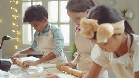 kids rolling dough during cooking lesson