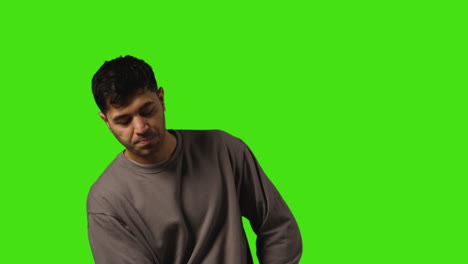 Young-Man-Getting-Alert-And-Looking-At-Text-Message-On-Mobile-Phone-Standing-Against-Green-Screen-2