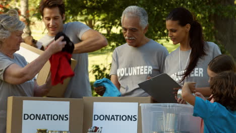 equipo de voluntarios felices recogiendo donaciones