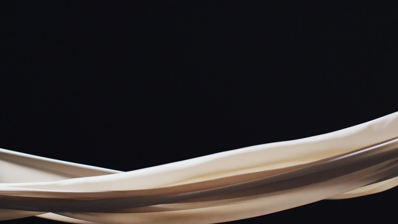 검은색 배경 위에 복사 공간과 함께  ⁇ 색 천을 불어 넣는 애니메이션