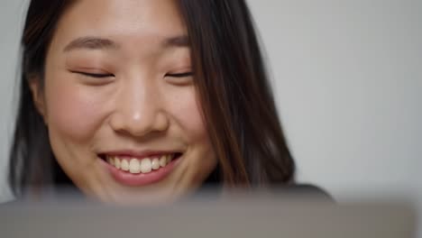 a young woman engaged in a joyful conversation while using her laptop, capturing the essence of connection and technology in a bright setting