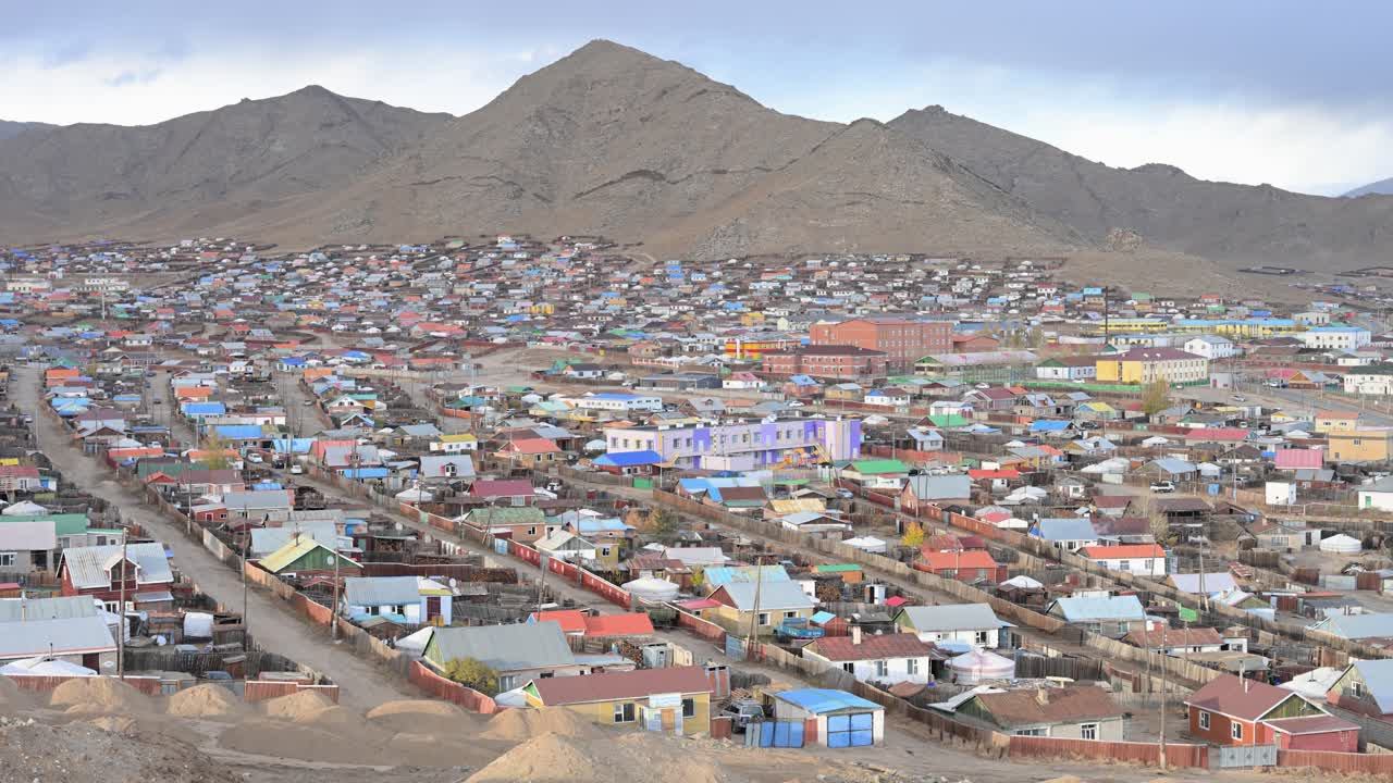 A moody, threatening storm builds over Uliastai, a remote provincial capital in Mongolia. This atmospheric, high-angle shot shows the sprawling city bracing for the approaching weather