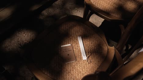 wooden wedding chair with a booklet and handkerchief placed under soft shadows
