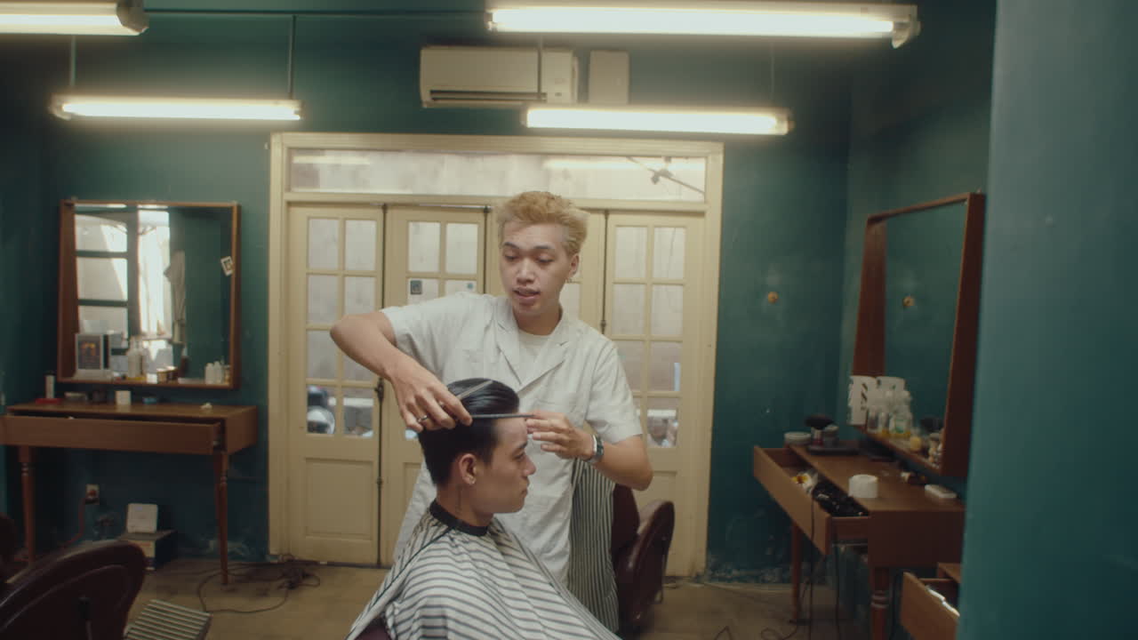 Asian Barber Giving Haircut and Talking to Male Client
