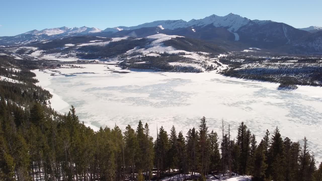 얼어붙은 호수와 뒤에 눈으로  ⁇ 인 산들이 드러납니다.