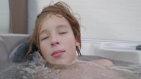 a teenager is sitting in a hot tub