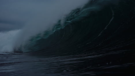 lip of wave comes crashing down on ocean water, view down barrel tube