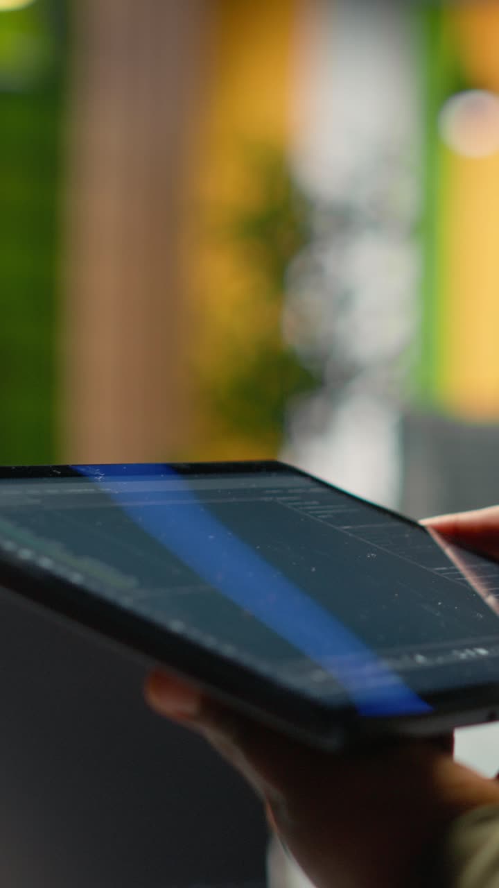 Vertical video Close up of IT professional in startup office working on tablet with AI