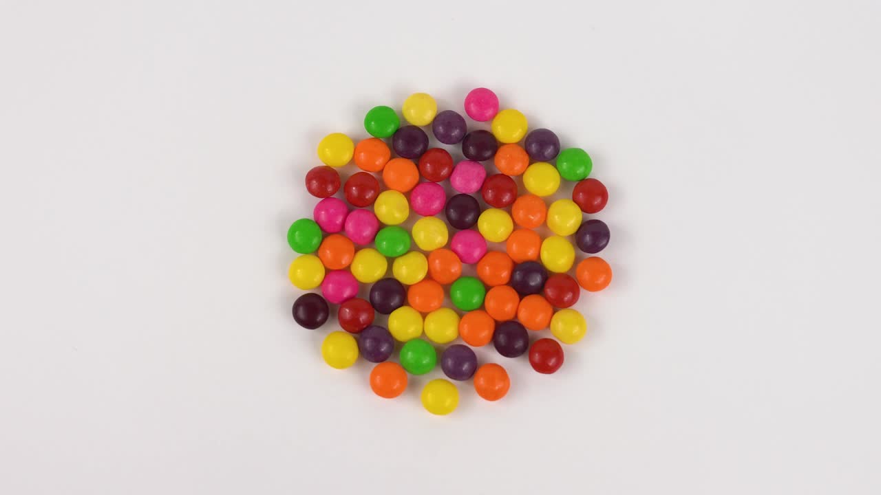 Top view round candy sweets rotated on white background. Loopable.