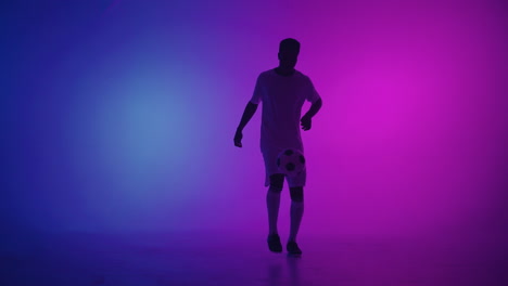 Black-african-man-Freestyle-or-professional-soccer-player-practicing-with-football-ball-juggling-on-legs-slow-motion.-Studio-shooting-of-a-professional-football-player-with-a-ball