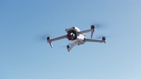 modern white drone hovering with blue clear sky for copy space in background