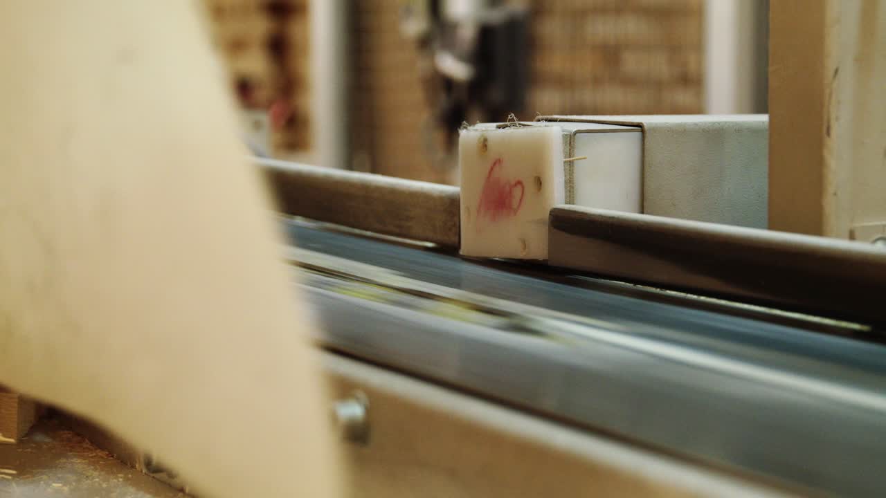 Detail of a factory production line. Small, numbered components move along a conveyor belt, showcasing an automated workflow in a modern industrial manufacturing process