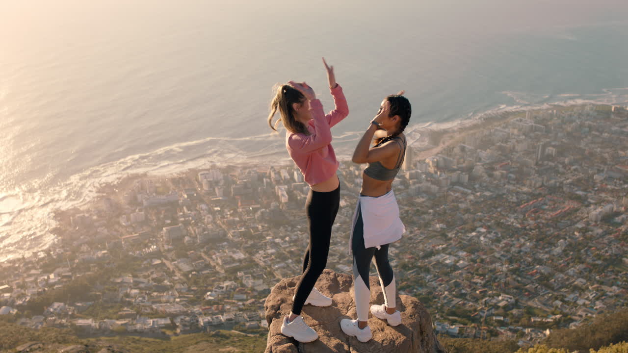 dos amigas de alto cinco celebrando el éxito de escalada de montaña en el desafío de senderismo divertirse aventura al aire libre logro