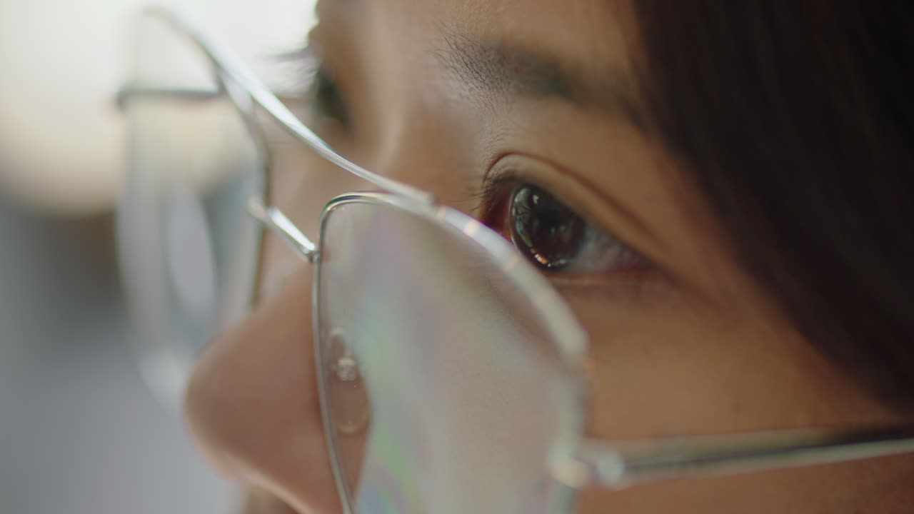 cerca de los ojos de la mujer asiática mirando pensativo pensando planeando hacia adelante usando gafas macro