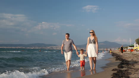 young family walking on the beach