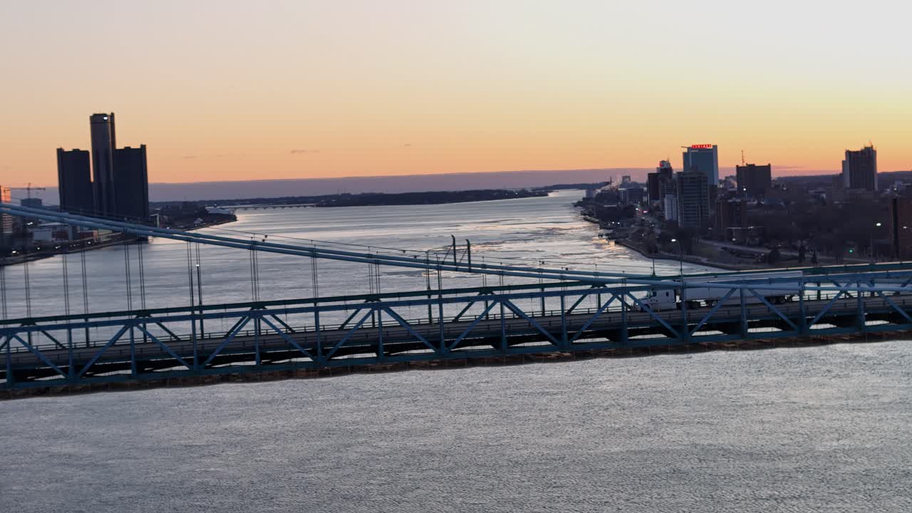 White semi truck speeding over Ambassador bridge, aerial drone view