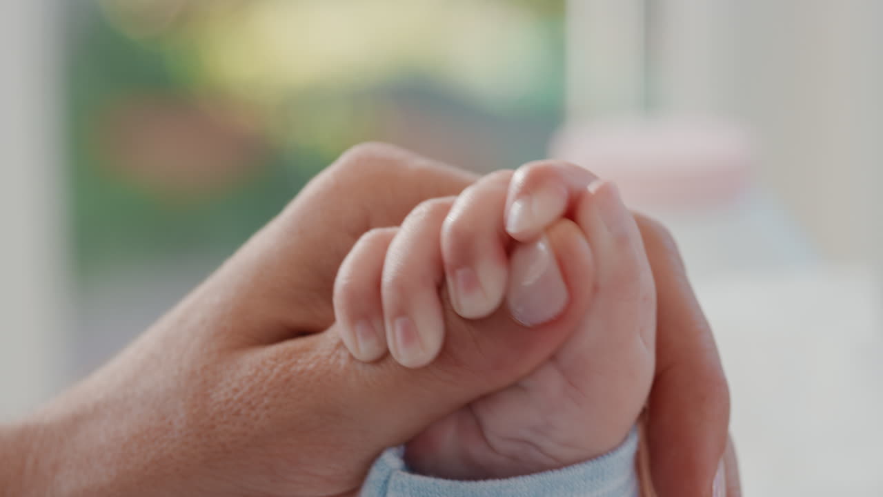 de cerca la madre sosteniendo al bebé con la mano tocando los dedos la madre cuidando al recién nacido cuidando del bebé en casa el amor de la maternidad 4k