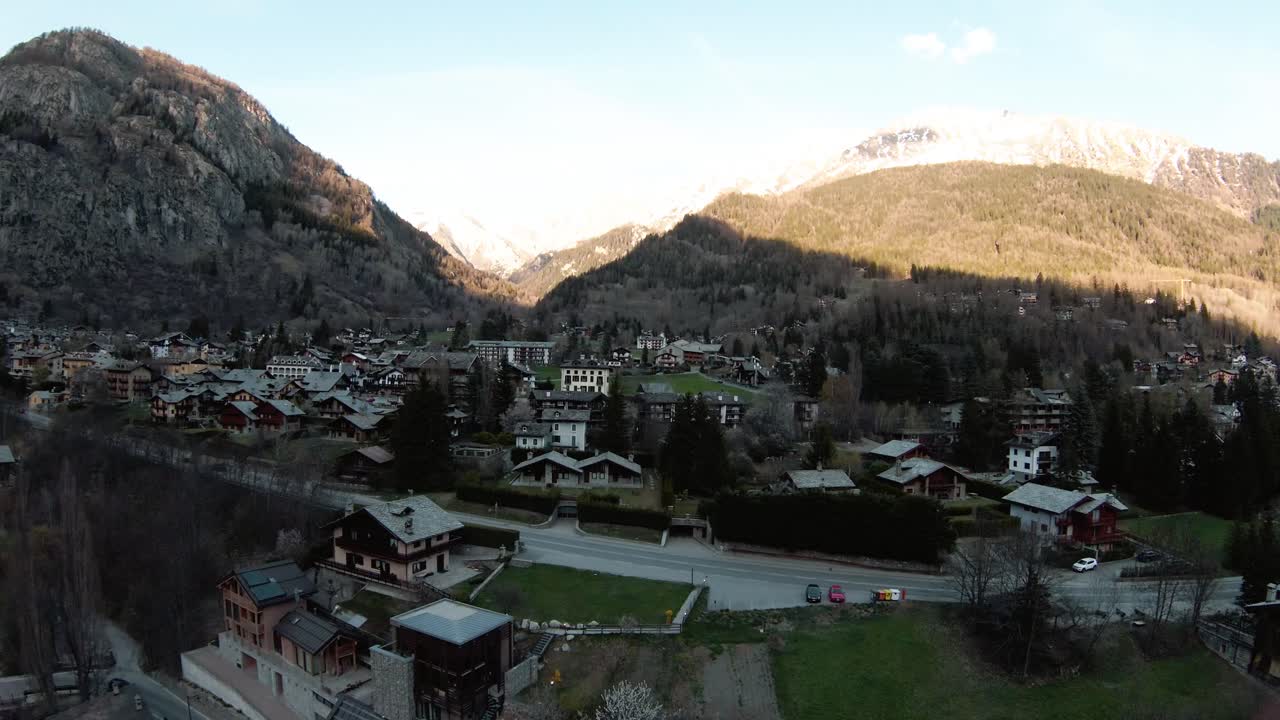 fpv drone antena en alpine mountain resort courmayeur, valle de aosta, italia al pie de los alpes mont blanc monte bianco, volando sobre casas y bosques