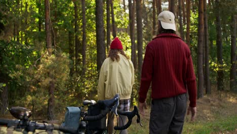 couple hiking in a forest with bikes