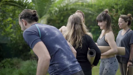 yoga group greeting with trainer in park