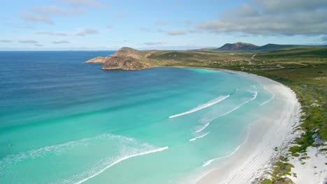 aerial view of a 4wd car in the beach, waves - lucky bay, australia - desending tilt, drone shot