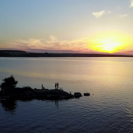 young people near river at sunset