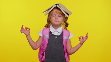 teenage girl in school uniform putting book on head, meditating, relaxing with concentrated thoughts