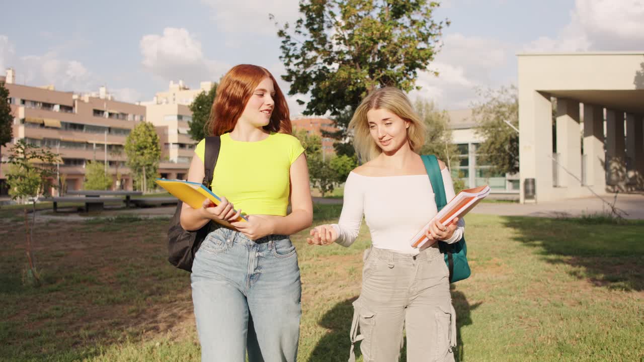 Two female students walking and talking on campus