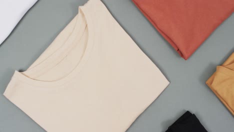 Video-of-flat-lay-of-t-shirts-with-copy-space-on-grey-background