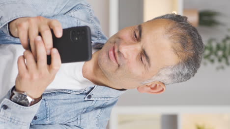 vertical video of dancing man with phone in hand.