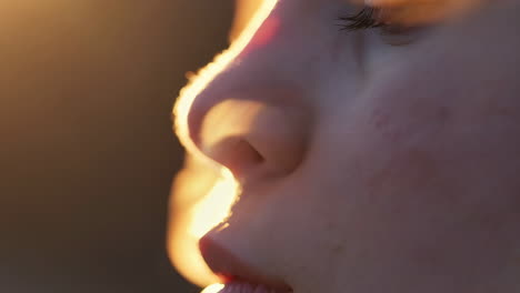 close-up profile of a person's face bathed in golden light