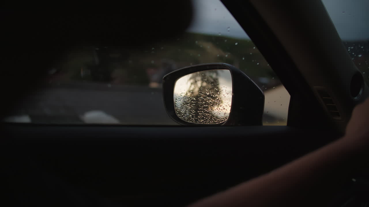 viaje por carretera lluvioso: una vista desde el espejo lateral