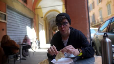 person eating bread and coffee in an italian street cafe