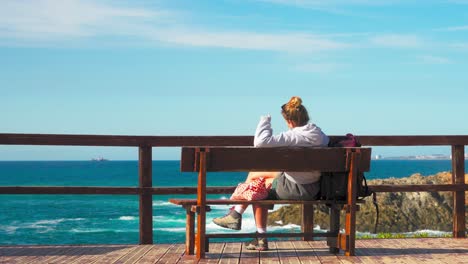 woman sitting on a bench contemplating the coastal view