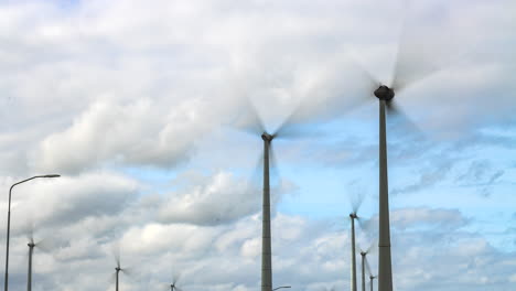 Wind-turbines-in-Eemshaven,-Netherlands,-spinning-rapidly-on-windy-day,-showcasing-renewable-energy-in-action