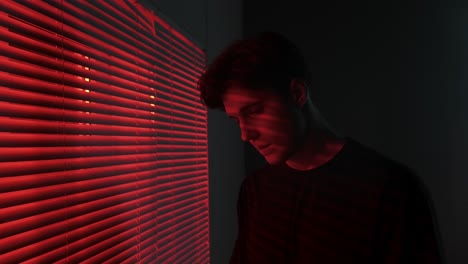 young man by window at night
