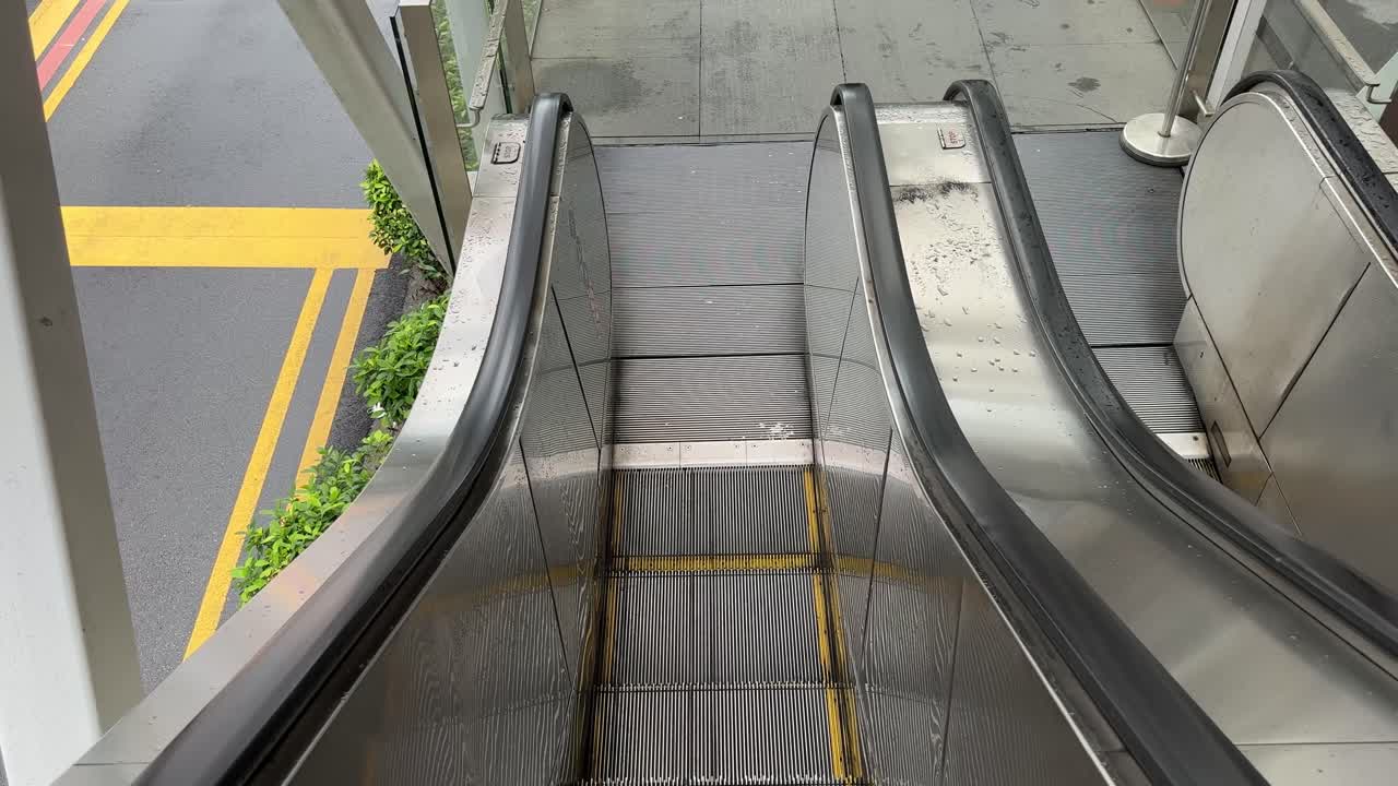 Blickwinkel einer leeren Rolltreppe im Freien, die nach unten fährt