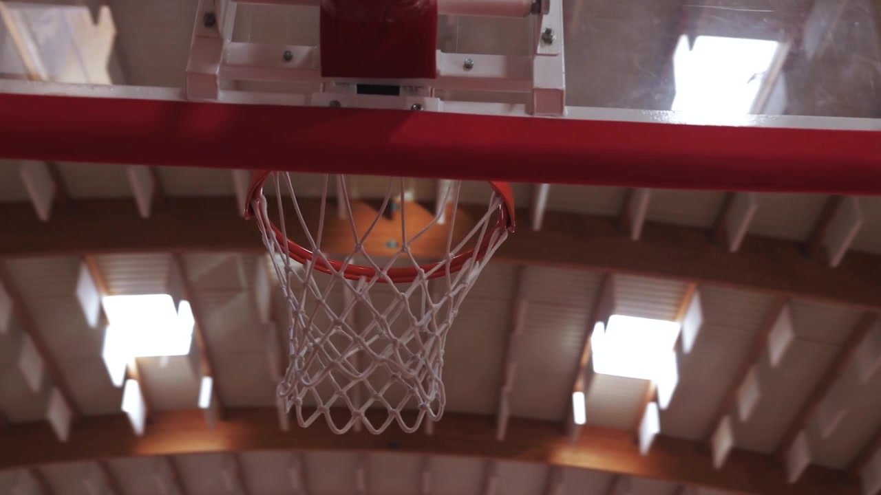 Tomada de acompanhamento dinâmica de cesta de basquete em câmera lenta ao redor da tabela dentro do estádio