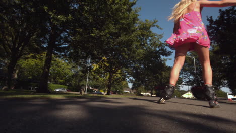 una rubia tonificada patinando en el parque.