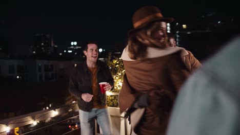 hombre negro y mujer caucásica bailando juntos en una fiesta en la azotea de la ciudad en la noche