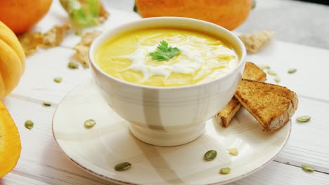 pumpkin soup in bowl served with bread