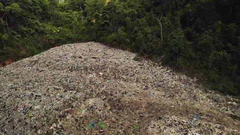 aerial tilt down footage of land fill garbage dump in the middle of the rain forest in thailand