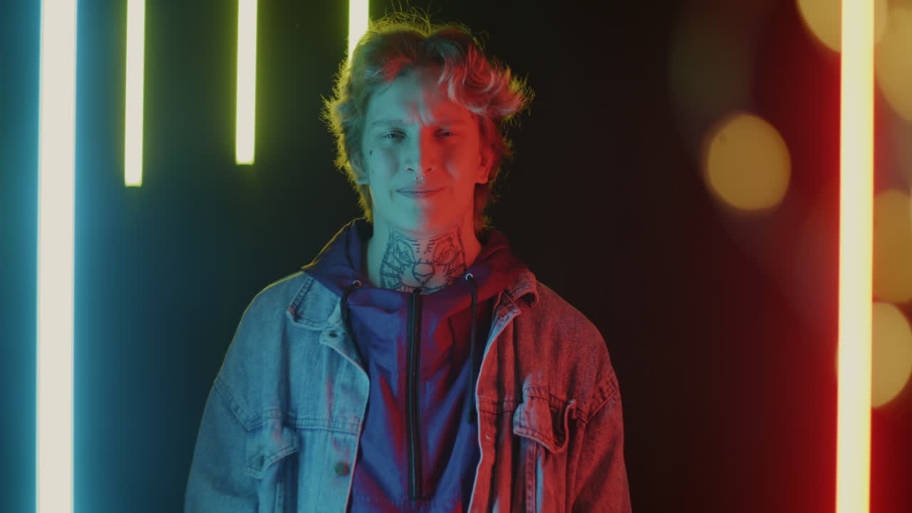 Stylish young person with a neck tattoo in neon light